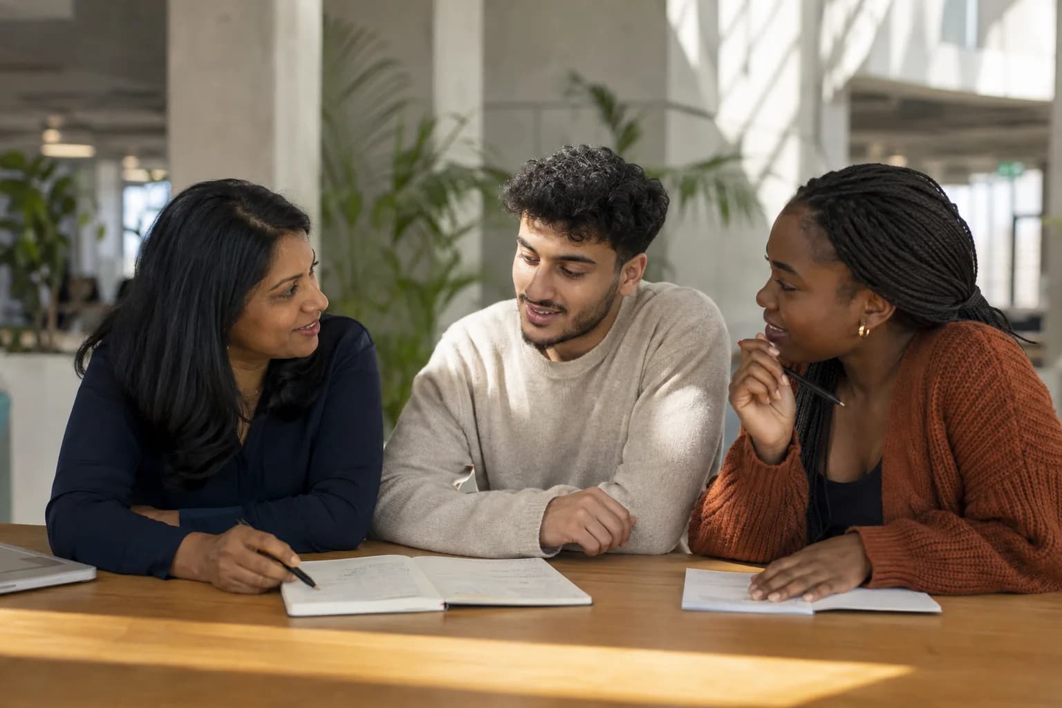 Three adults working through a problem together at a table